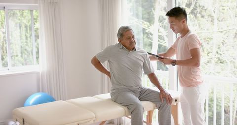 Senior Man and Physiotherapist Discussing Treatment Options
