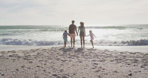 Family Holding Hands Walking on Scenic Beach at Sunset - Download Free Stock Images Pikwizard.com