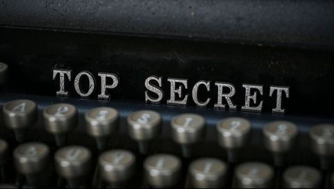 Vintage typewriter showing top secret embossed metal letters with round keys