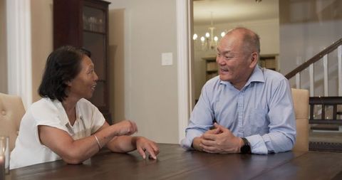 Asian Senior Couple Engaging in Conversation at Home
