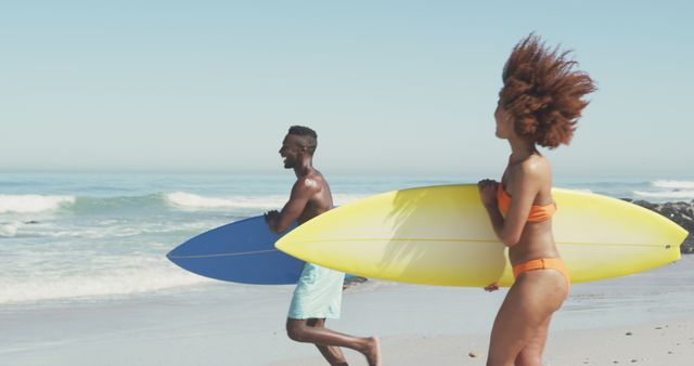 Group of friends carrying surfboards along beach on a sunny day. Ideal for use in promotions related to summer vacations, beach activities, surfing events, outdoor activities, and travel advertisements.