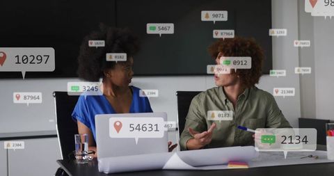 Colleagues discussing data overlays and location tags during office collaboration meeting