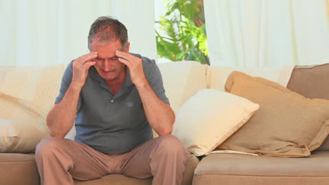 Elderly Man Contemplating on Sofa at Home