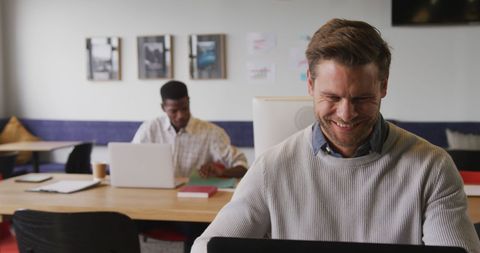 Happy Businessman Focused on Laptop in Office