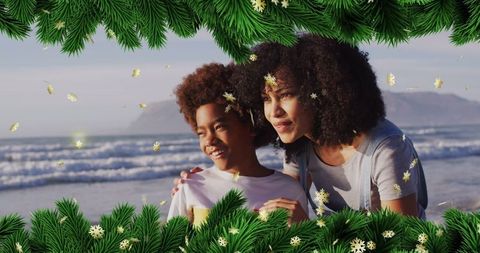 Mother and son enjoying winter beach with festive overlay