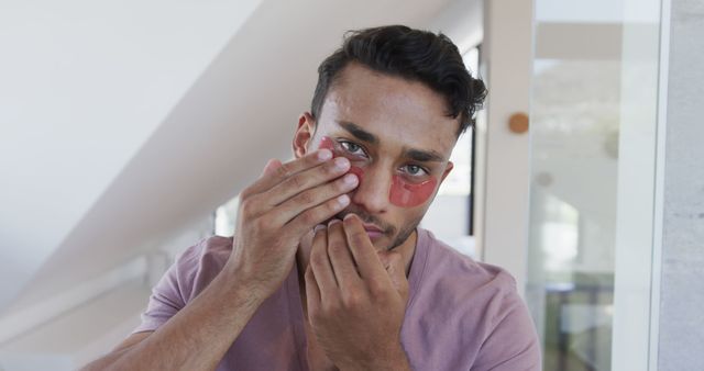 Young Man Applying Under Eye Patches for Skincare - Download Free Stock Images Pikwizard.com