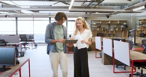 Colleagues Collaborating in Modern Office Space with Tablet