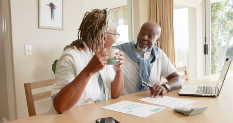 Elderly Couple Managing Finances Together at Home Over Coffee