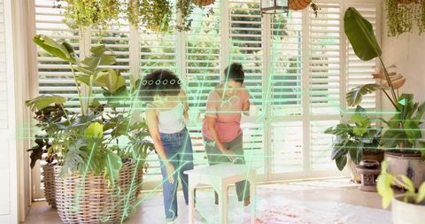 Mother and daughter assembling stool in sunlit indoor garden using augmented reality overlay