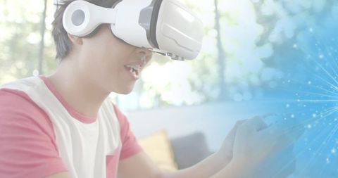 Young man experiencing immersive vr gaming with white headset and holographic blue overlay