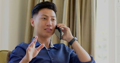 Asian professional talking on phone during home relaxation