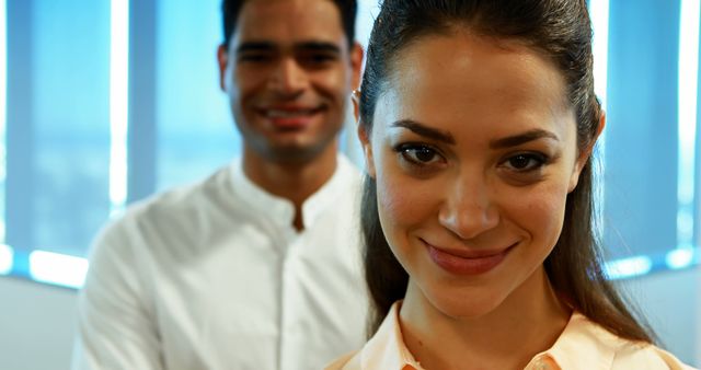 Confident Businesswoman Smiling with Coworker in Background at Office - Download Free Stock Images Pikwizard.com