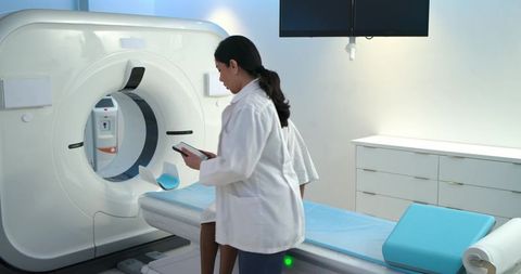 Preparing patient for ct scan in modern radiology suite with clinician using tablet
