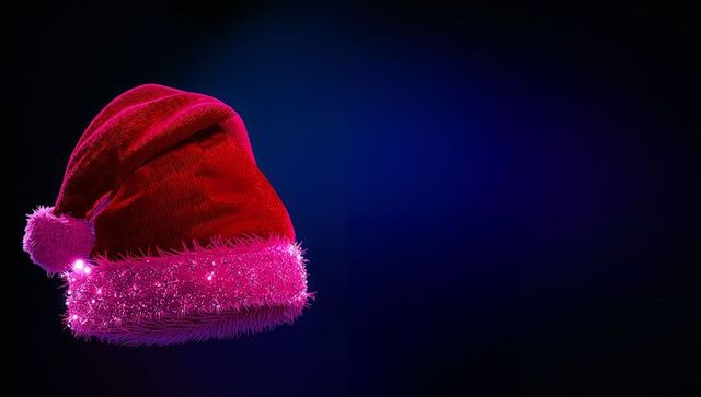 Red Velvet Santa Hat with Glowing Magenta Tinsel on Dark Blue Background