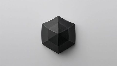 Matte Black Faceted Hexagonal Polyhedron on Light Gray Surface