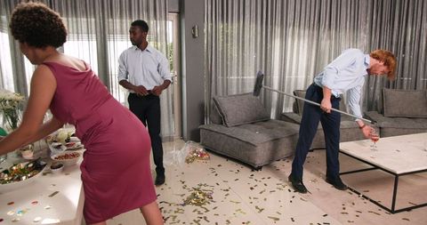 Friends Cleaning Confetti After Wedding Reception in Living Room
