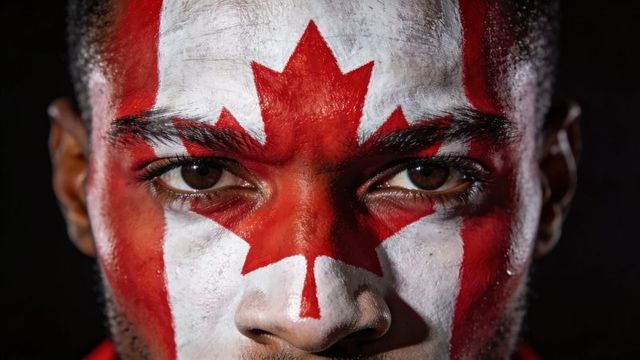Staring man with canadian flag face paint close-up portrait showing intense gaze