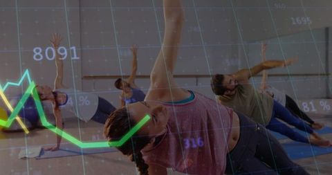 Performing side-plank in pink tank and dark leggings during group fitness class
