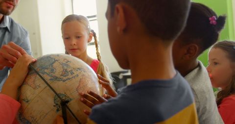 Teacher engaging young students in classroom with globe