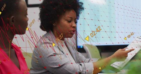Leader pointing and reviewing report with analytics overlay while colleague listening