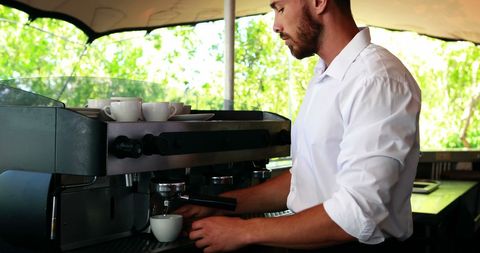 Skilled Barista Brewing Fresh Espresso at Cafe
