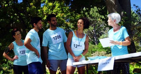 Diverse Group of Athletes Engaging at Outdoor Event Check-In - Download Free Stock Images Pikwizard.com