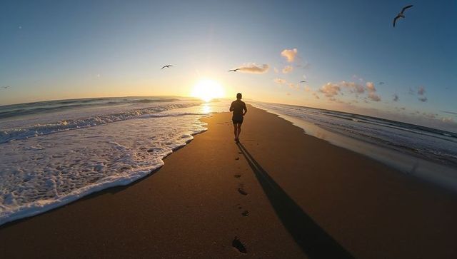 Morning Run on Ocean Shoreline with Sunrise in Background
