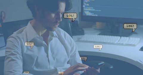 Young professional holding smartphone reading code, lol chat bubbles floating over workstation