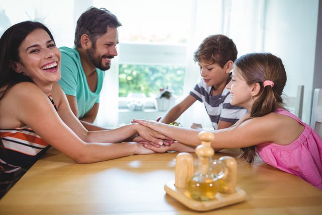 Parents and kids putting their hands together on table - Download Free Stock Photos Pikwizard.com