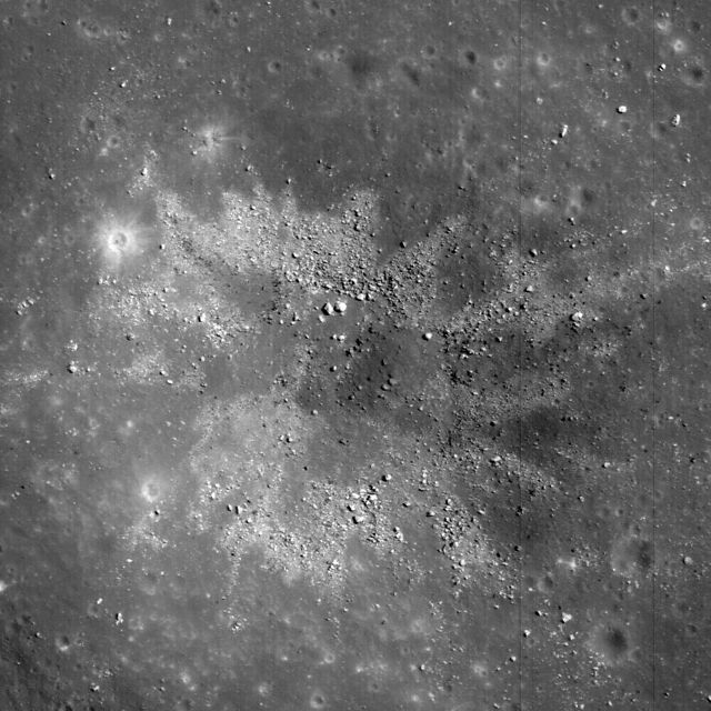 Image of an approximately 450-meter diameter impact crater showing two-toned materials in Balmer Basin. Likely reflects heterogeneity in target materials on the lunar surface. Captured by NASA Lunar Reconnaissance. Can be used for educational materials, space science articles, and discussions about lunar geology and space exploration.