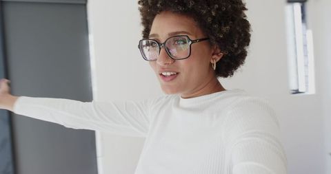 Stylish woman presenting modern bright apartment interior