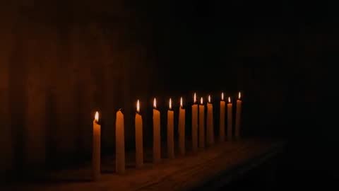 Ambient Candlelight Flickering on Rustic Wooden Table in Dim Room
