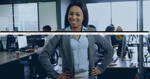 Confident female tech leader standing in open office with code overlay and team