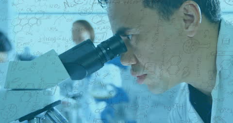 Scientist Observing Through Microscope in Chemistry Lab