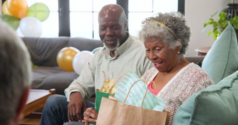 Multiracial Senior Friends Celebrating with Gifts and Joyful Laughter