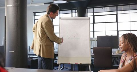 Businessman presenting growth chart in modern office meeting