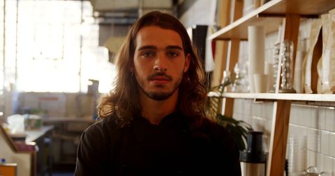 Young artisan standing confidently in workshop setting