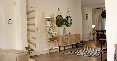 Midcentury minimal living room with wooden console, ladder shelf and hanging mirrors