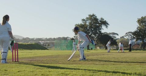 Women enjoy cricket match on sunny day outdoors
