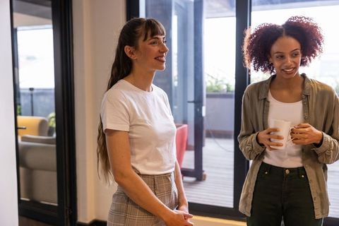 Businesswomen Engaged in Casual Office Conversation with Coffee