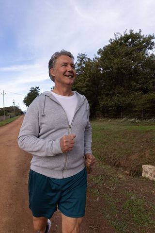 Senior man enjoying outdoor jog along countryside path