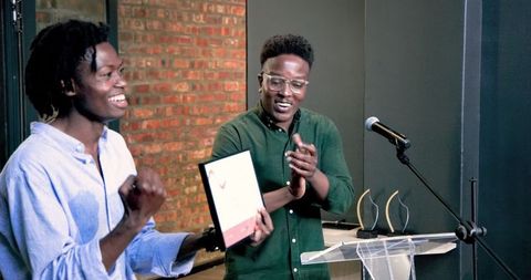 Colleagues presenting awards at corporate event in modern office