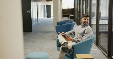 Professional Man Using Tablet in Modern Office Corridor