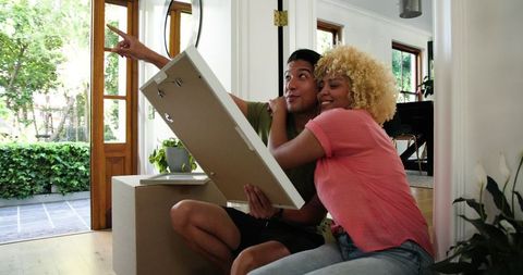 Young Couple Planning Home Decor While Unpacking Boxes
