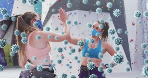 Masked Rock Climbers High-Fiving Amongst Virus Models at Climbing Gym