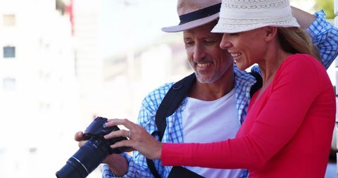 Mature couple reviewing photos on digital camera outdoor