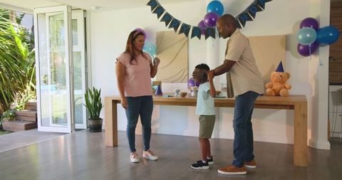 Diverse Family Celebrating Child's Birthday at Home with Joyful Decorations