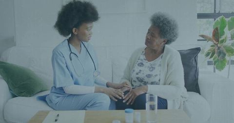Nurse Comforting Elderly Patient At Home
