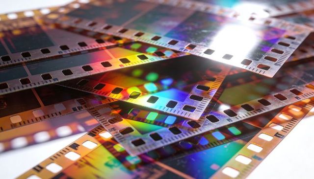 Overlapping 35mm film negatives with iridescent rainbow glare and macro sprocket details