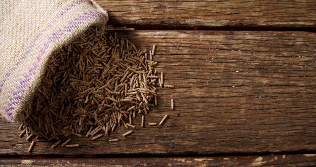 A burlap sack spills cumin seeds onto a rustic wooden surface. Cumin is a popular spice used in various global cuisines for its warm, earthy flavor.